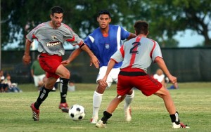 Dominic Schell of Dallas Roma FC dribbles the ball against Miami FC during the 2006 US Open Cup Second Round match as teammate Beau Brown (No. 2) looks on. Photo: Dallas Roma FC