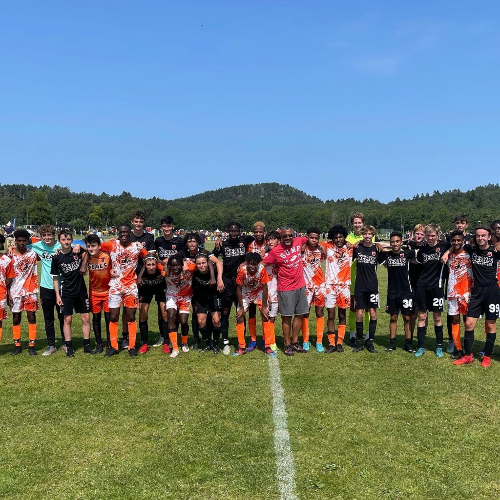 Shani Simpson (middle, red shirt) poses with San Francisco Bay Seals youth academy players after a match in Kenya. Photo: San Francisco Bay Seals